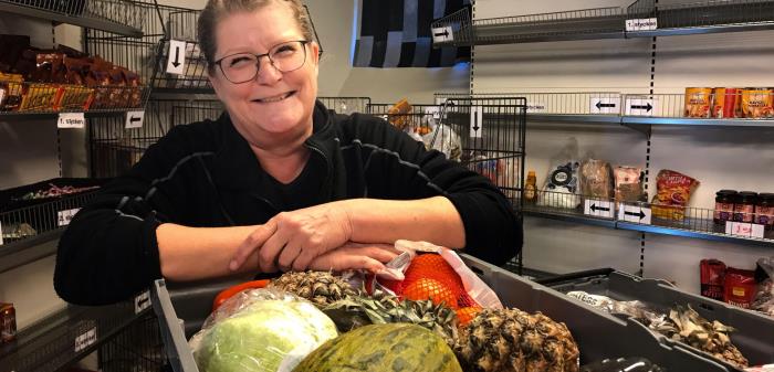 Bilden visar Lena vid nyinkomna varor på Matcentralen.