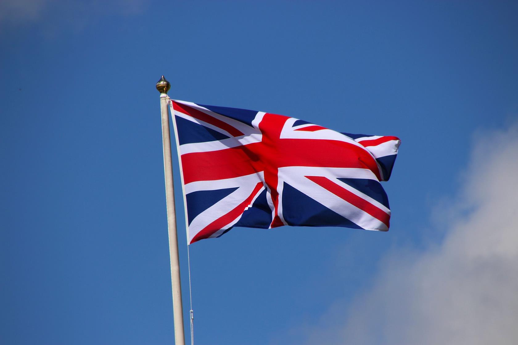 Bilden visar den brittiska flaggan på flaggstång, blå himmel i bakgrunden.