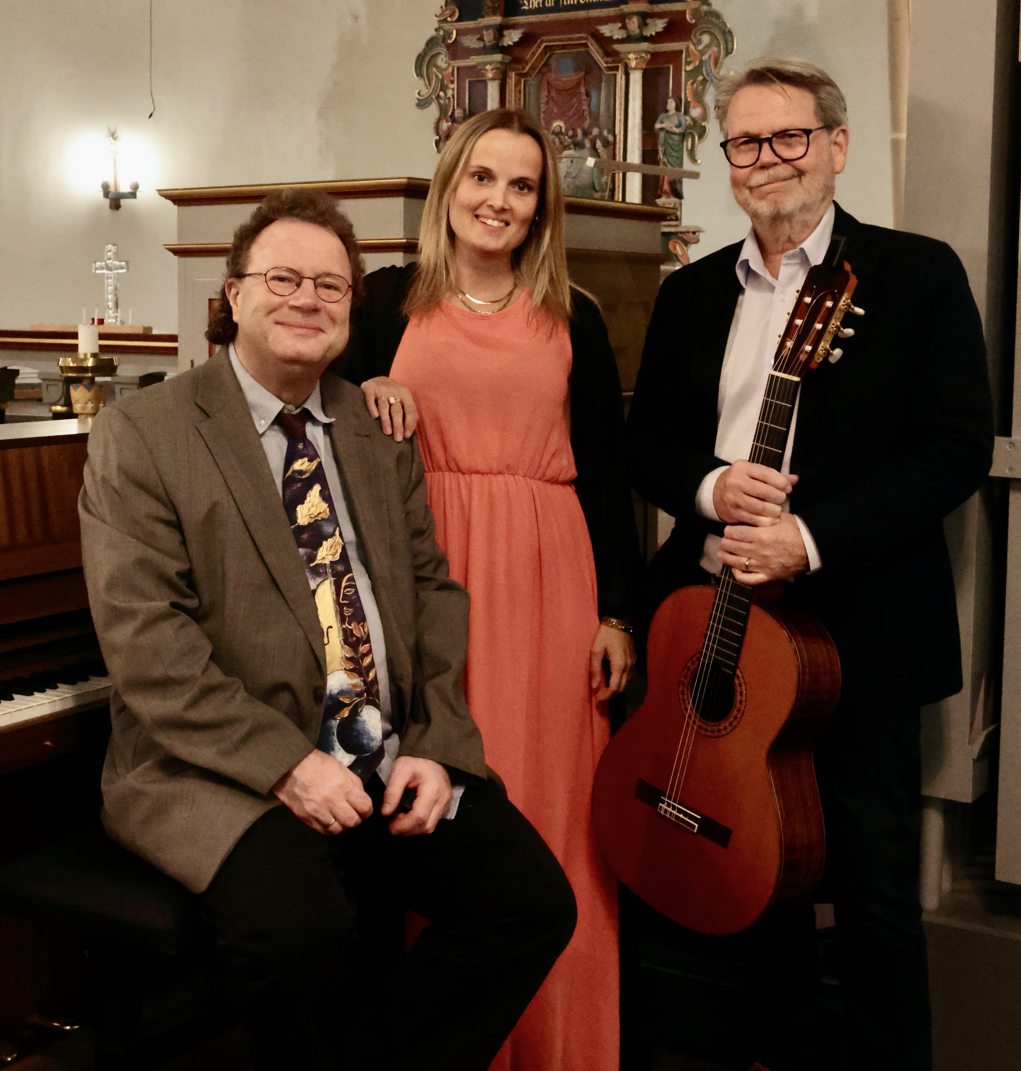 Tre musiker i en kyrka: Anna Falkström Bornhager, sång. Stefan Petzén, gitarr och sång. Stefan Wikrén, piano, orgel och sång.