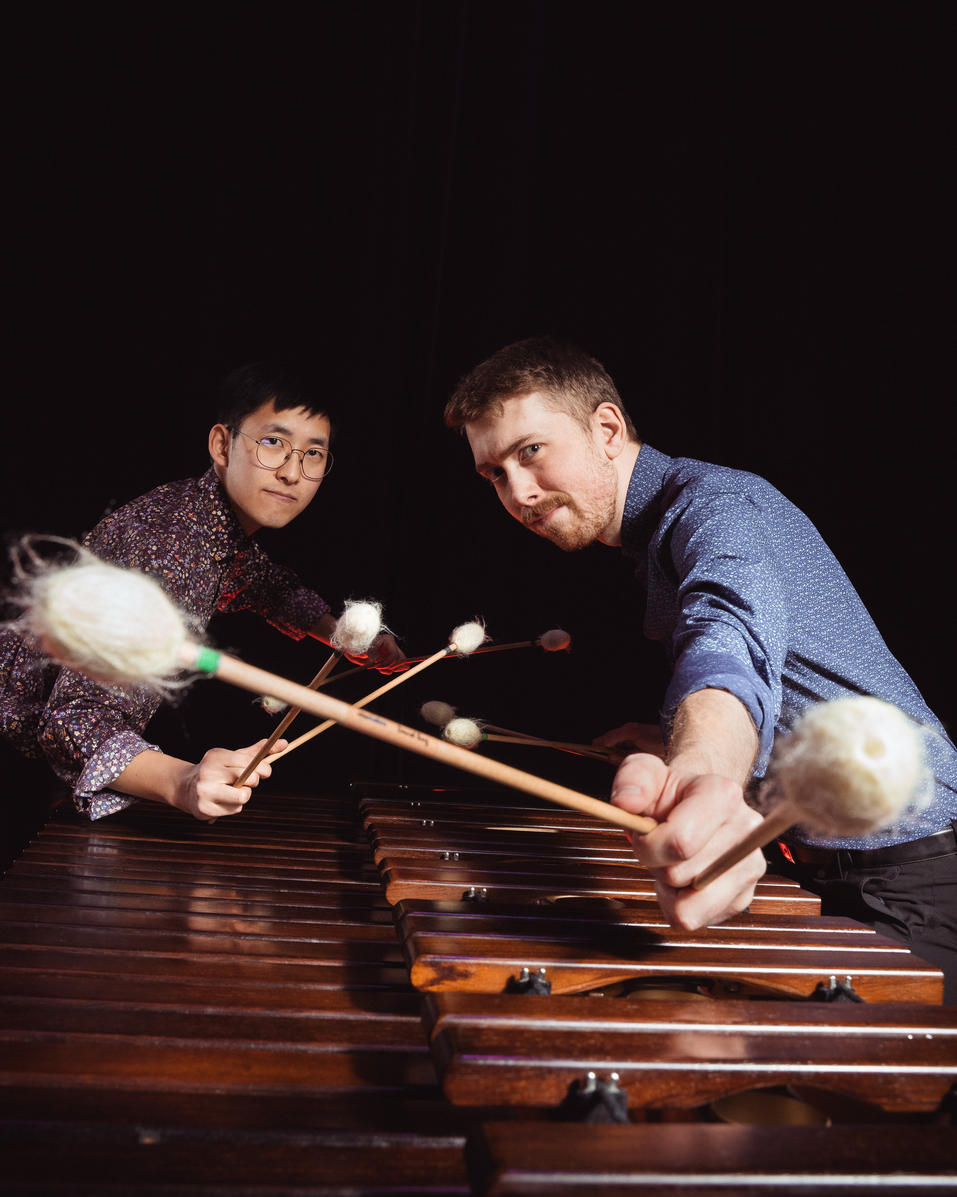 Duo Ictus står mot svart bakgrund lutade mot varandra över två marimbor.