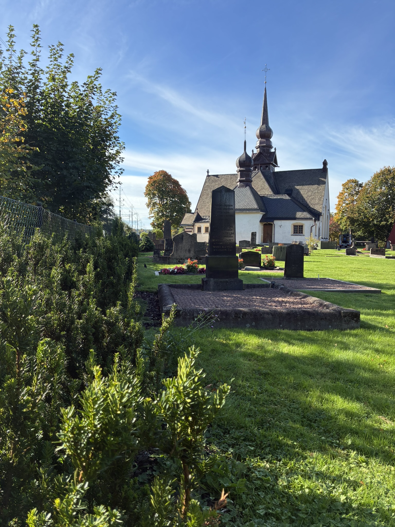 Lerums kyrka med vintergrönhäck i höstsolen