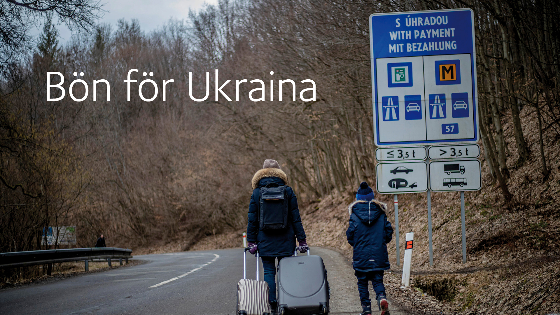 En vuxen och ett barn gåendes på flykt från Ukraina.