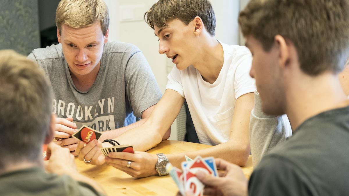 Några pojkar i tonåren spelar kortspelet Uno.
