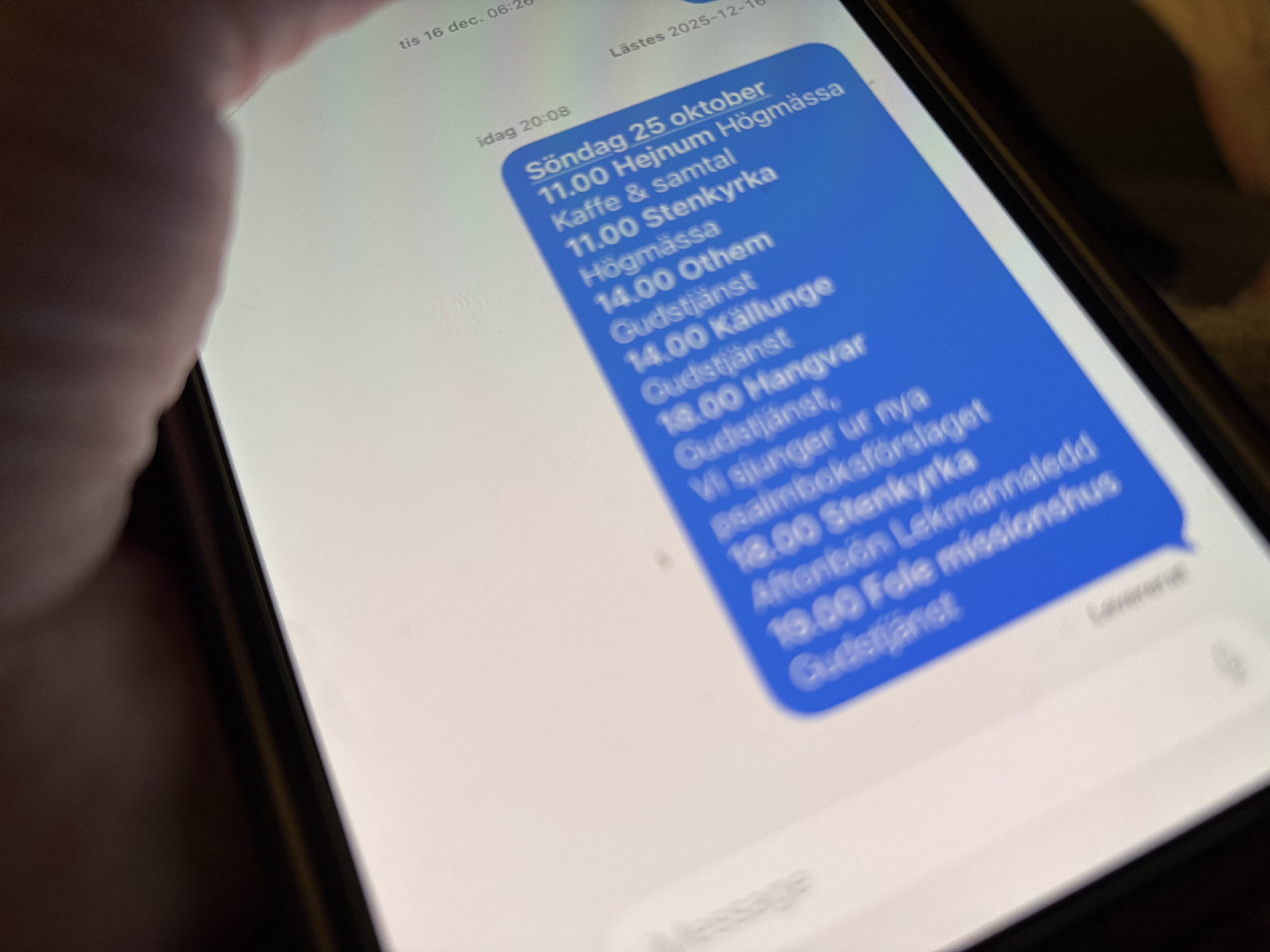 en mobil vars skärm visar ett sms med information om vad som ska hända i kyrkorna