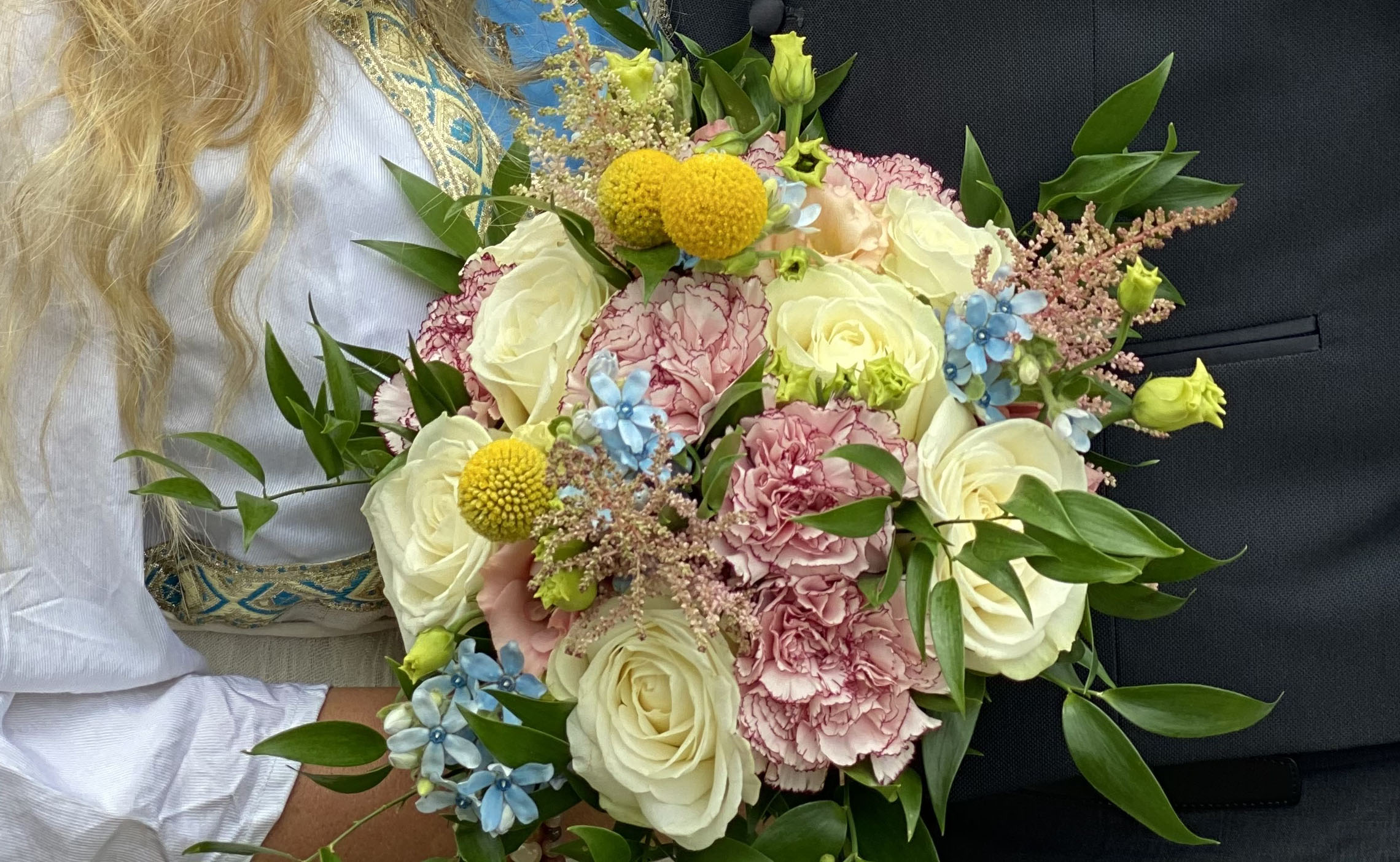 En brudbukett i ljusa färger med sommarblommor