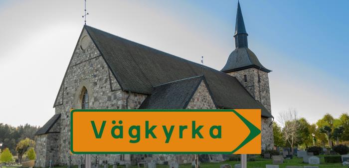 Bild på Botkyrka kyrka. Framför kyrkan finns en orange vägskylt där det står "Vägkyrka" med grön text