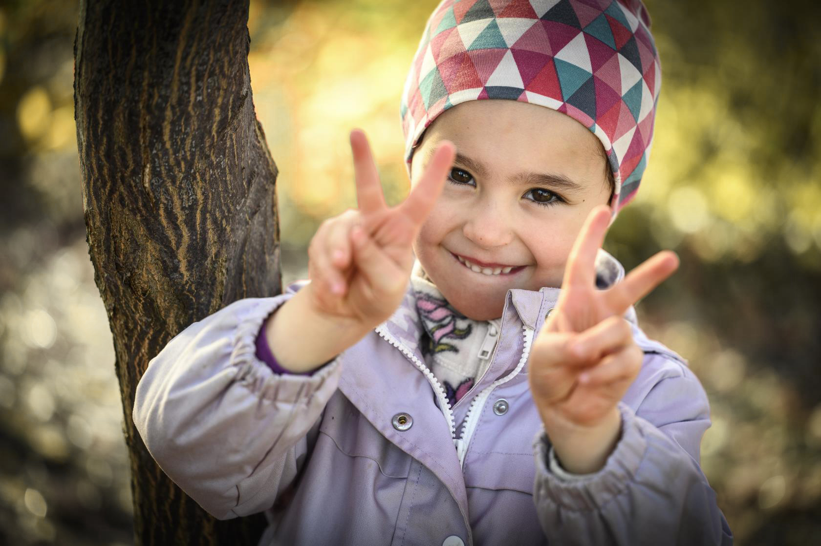 Barn tittar in i kameran och ler.