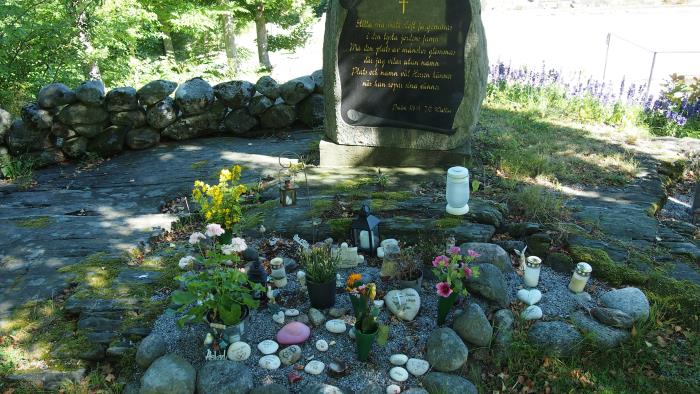 Minneslunden på Stenkyrka kyrkogård med ljus, blommor och minnessaker
