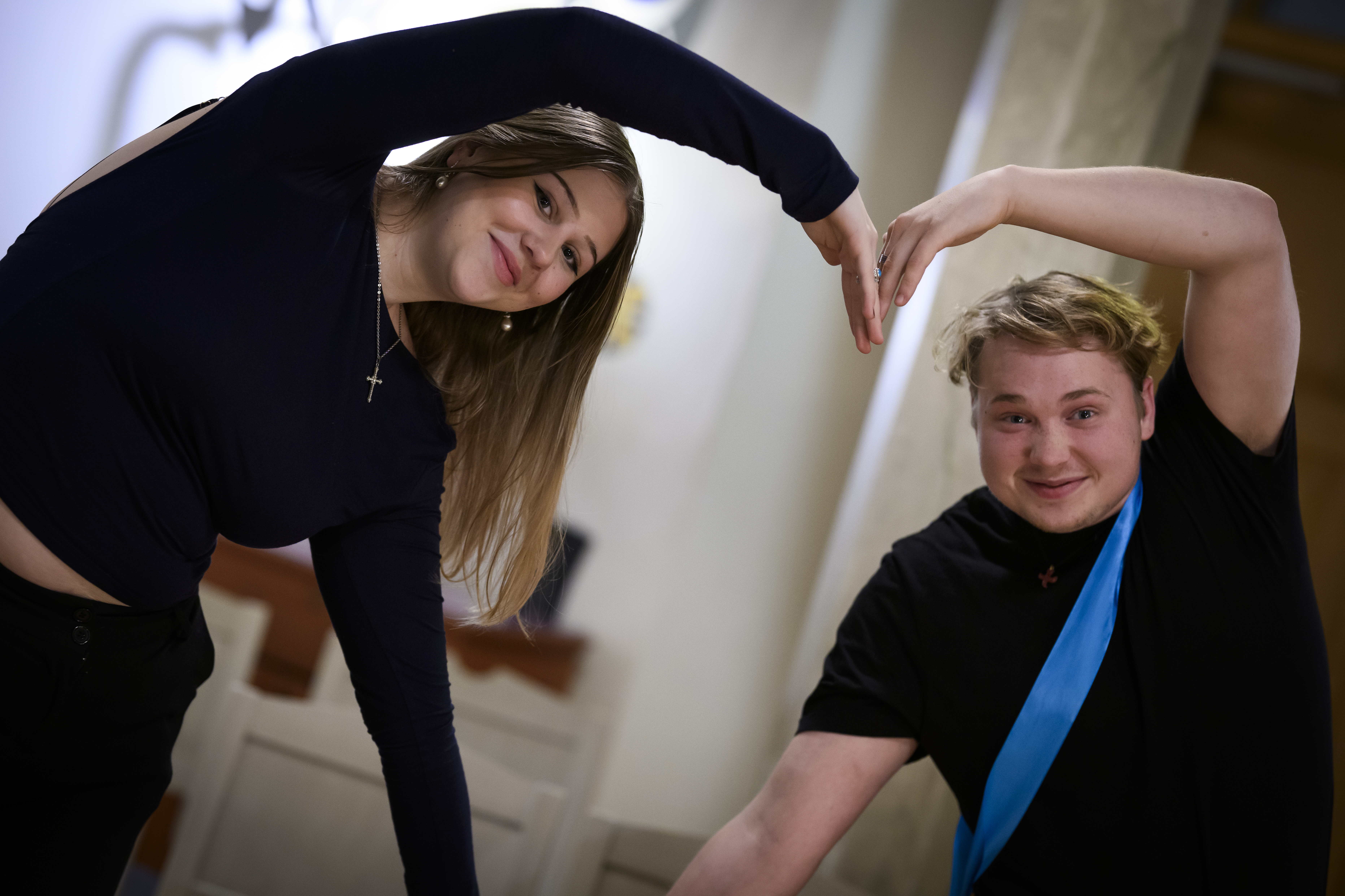 Två ungdomar som formar ett hjärta med sina armar