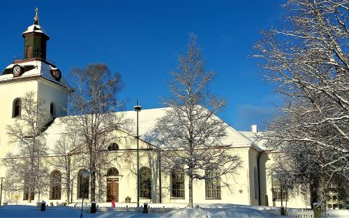 Svegs kyrka i vinterskrud, solsken och klarblå himmel.