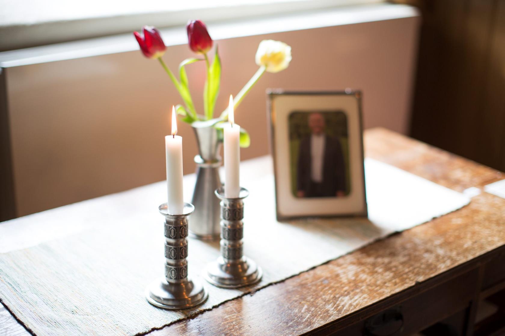 Ett minesbord med blommor, ljus och fotografi över den avlidne.