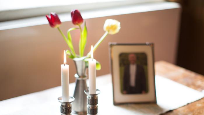 Ett minesbord med blommor, ljus och fotografi över den avlidne.