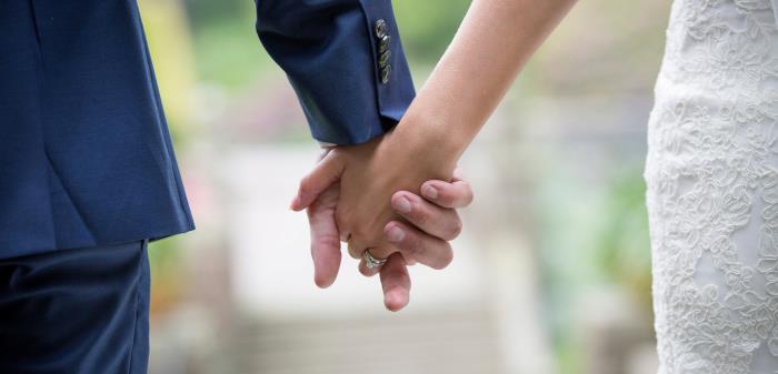 Bröllopspar håller varandra i händerna