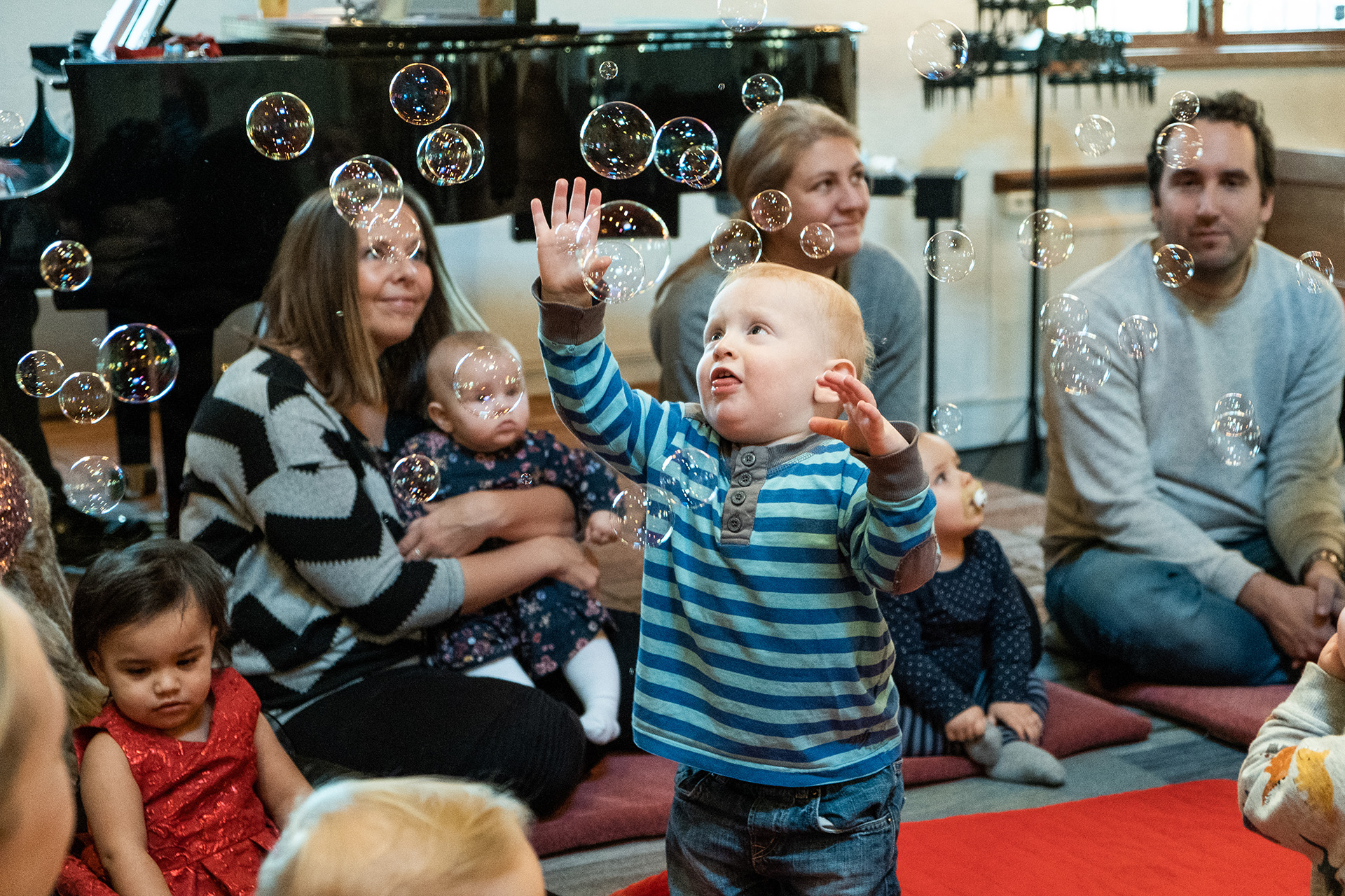 Bebis leker med bubblor på aktivitet i kyrkan för föräldrar och barn.