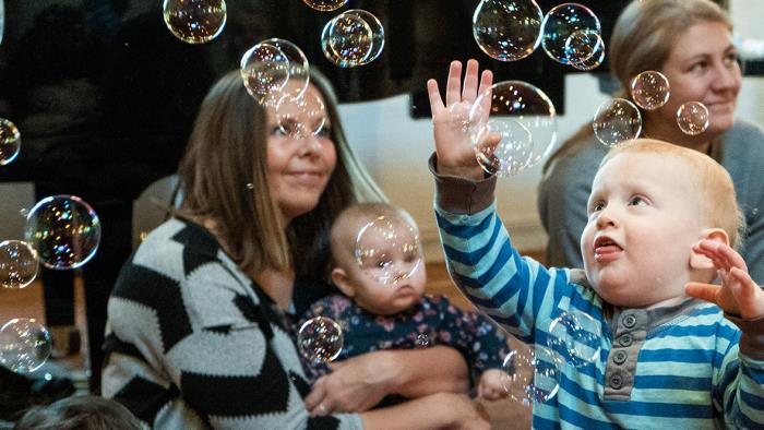 Bebis leker med bubblor på aktivitet i kyrkan för föräldrar och barn.