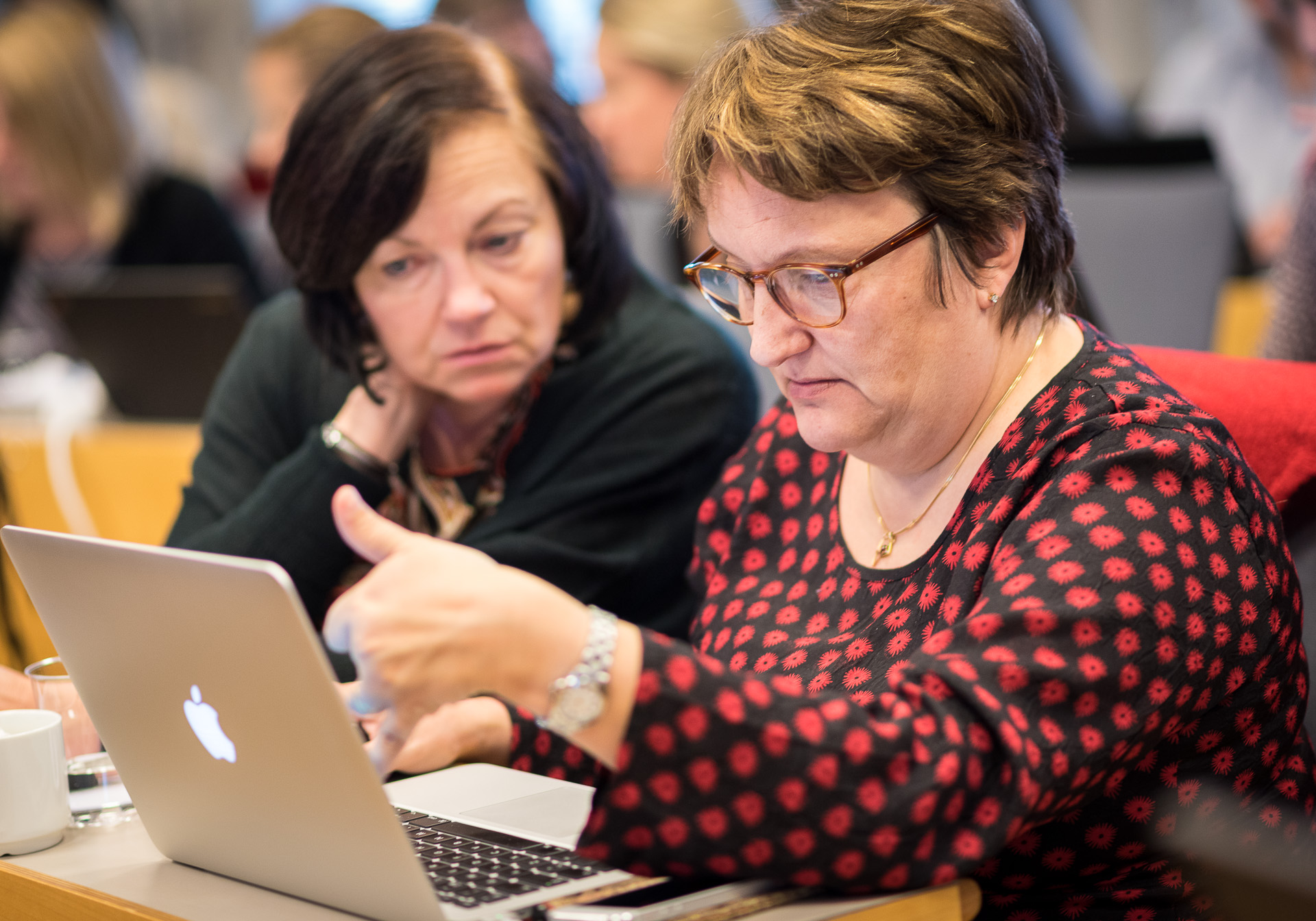 Två webbredaktörer tittar intensivt på en datorskärm.