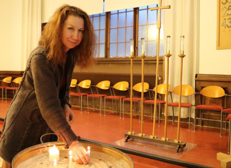 Elisabet Hartman, präst i Malmö Sankt Pauli, tänder ljus i församlingshuset där man firat gudstjänst sedan renoveringar tog sin början. 