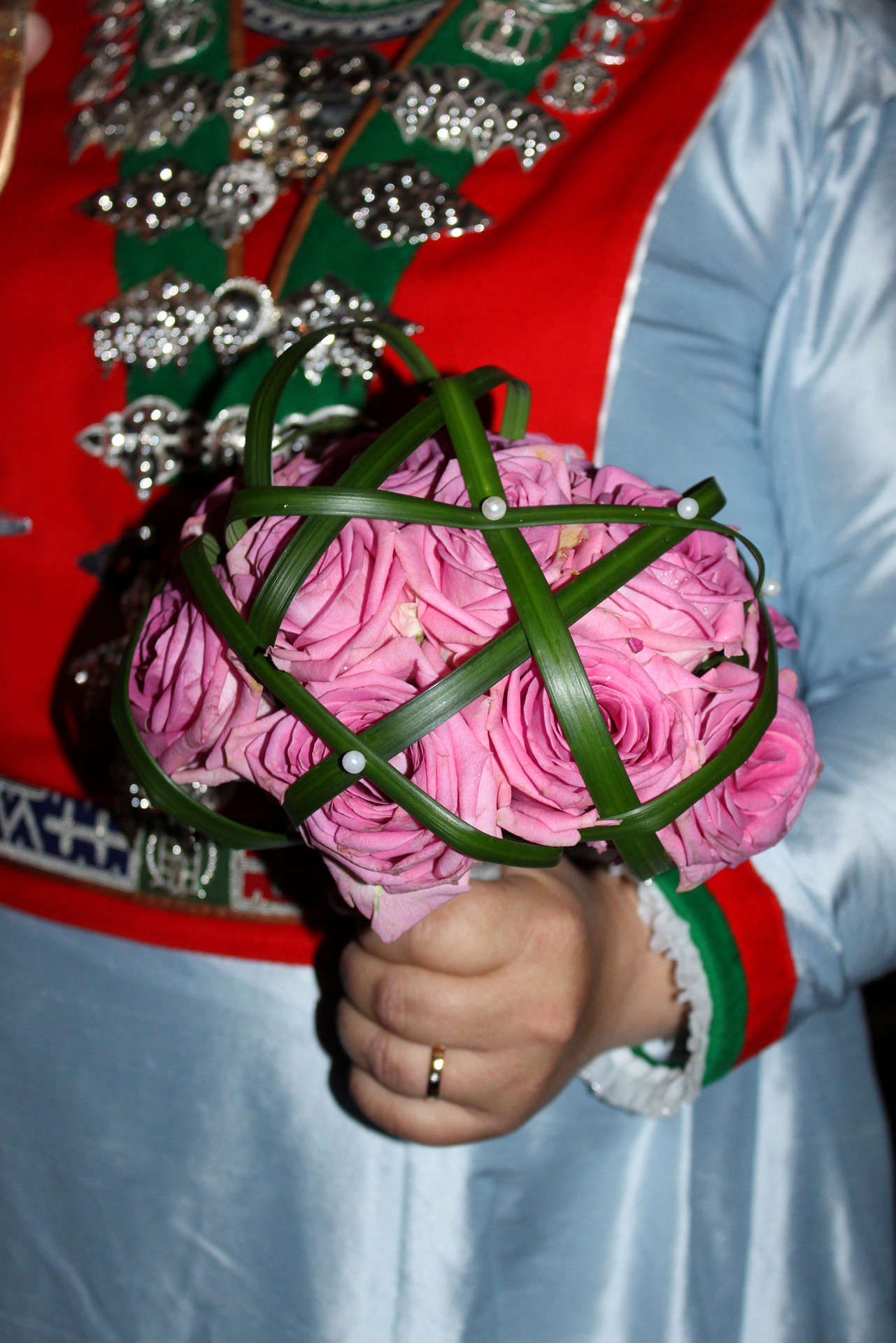 Brudbukett i handen på en brud i samiska bröllopskläder