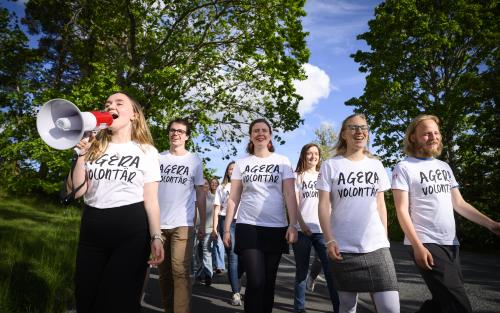 Grupp ageravolontärer som sopar ut sitt budskap i en magafon.