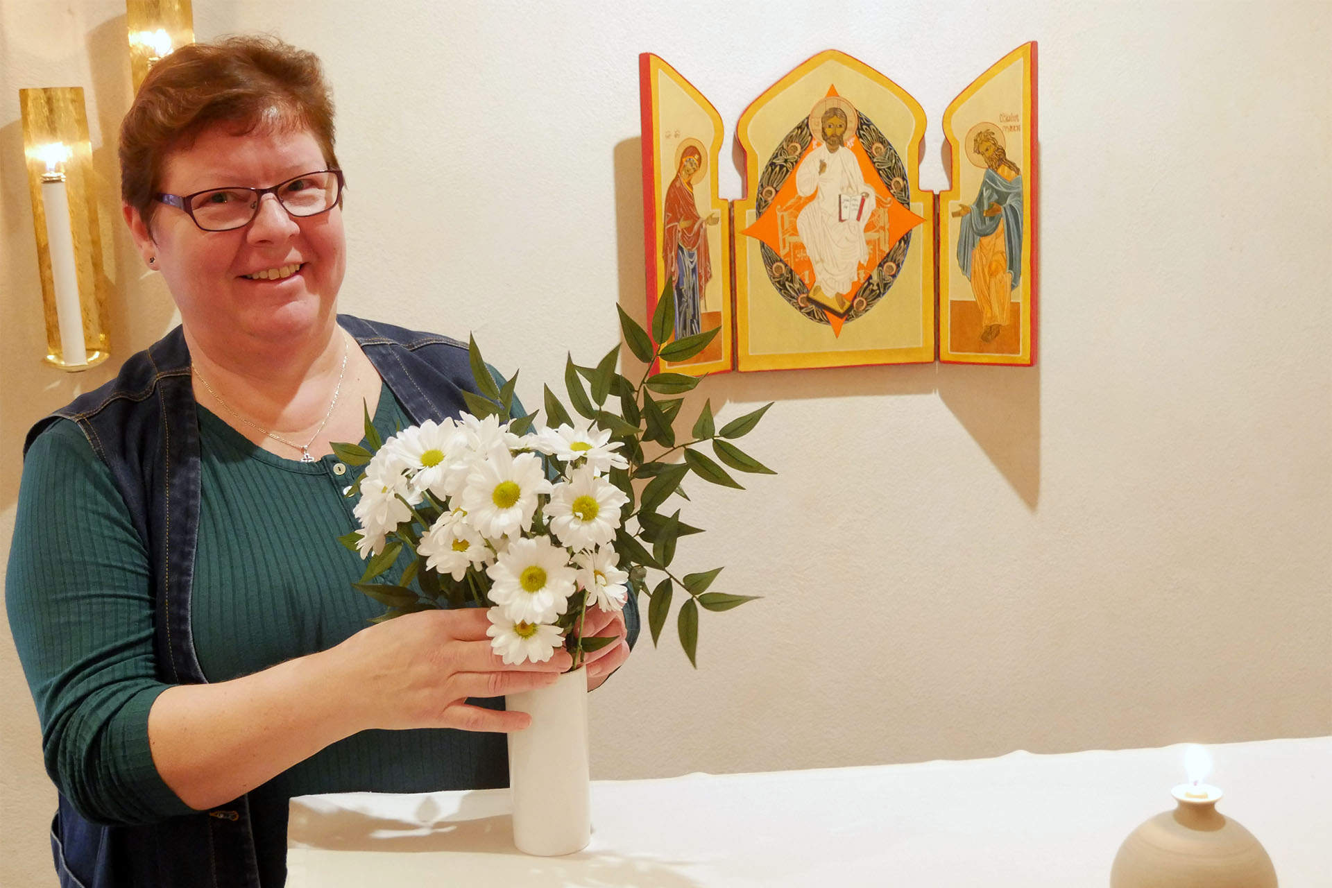 Gunnel Carlsson ordnar altarblommor i kapellet i S:t Hans kyrka. 