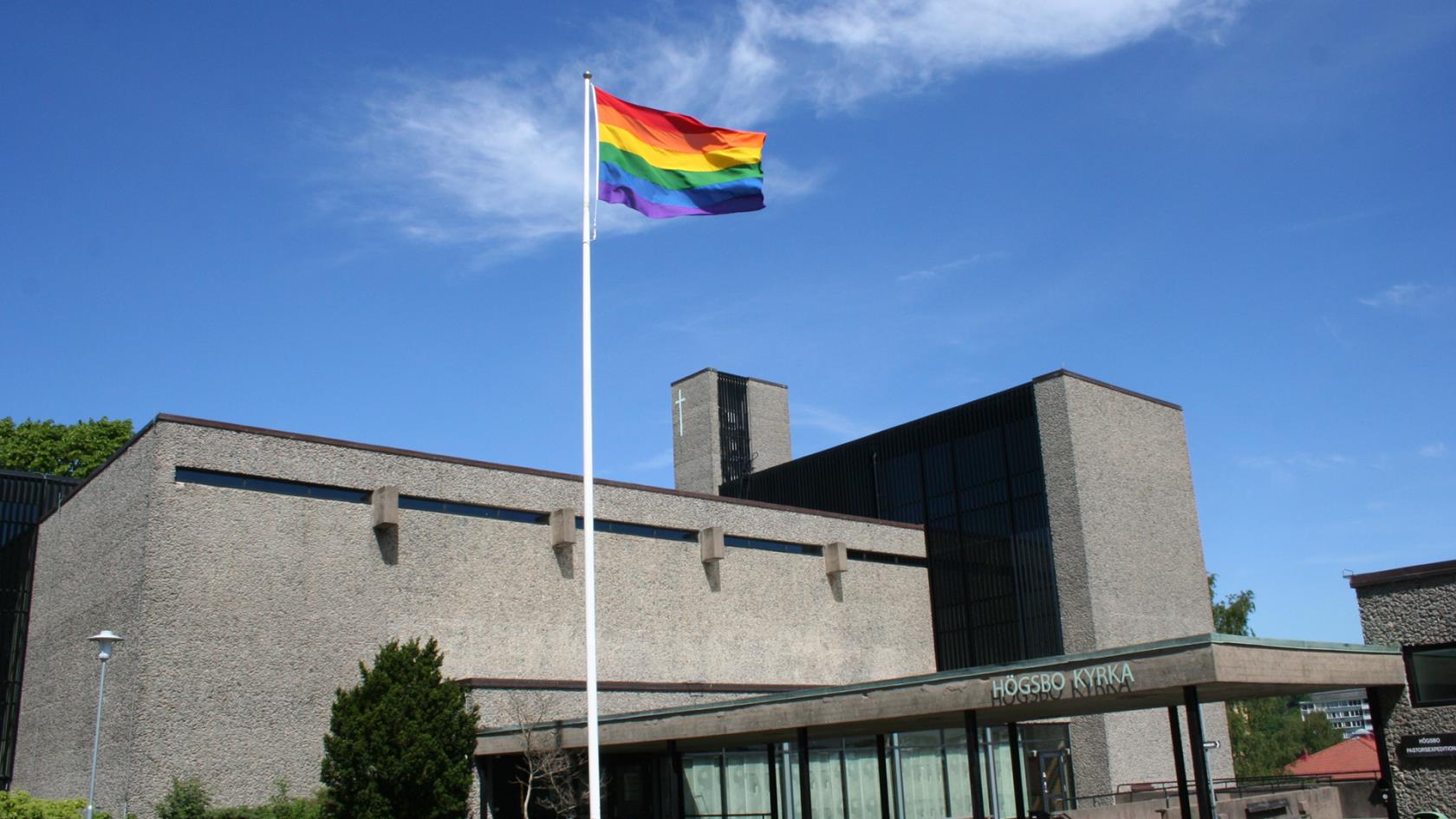 Högsbo kyrka utifrån. HBTQ-flaggan är hissad.