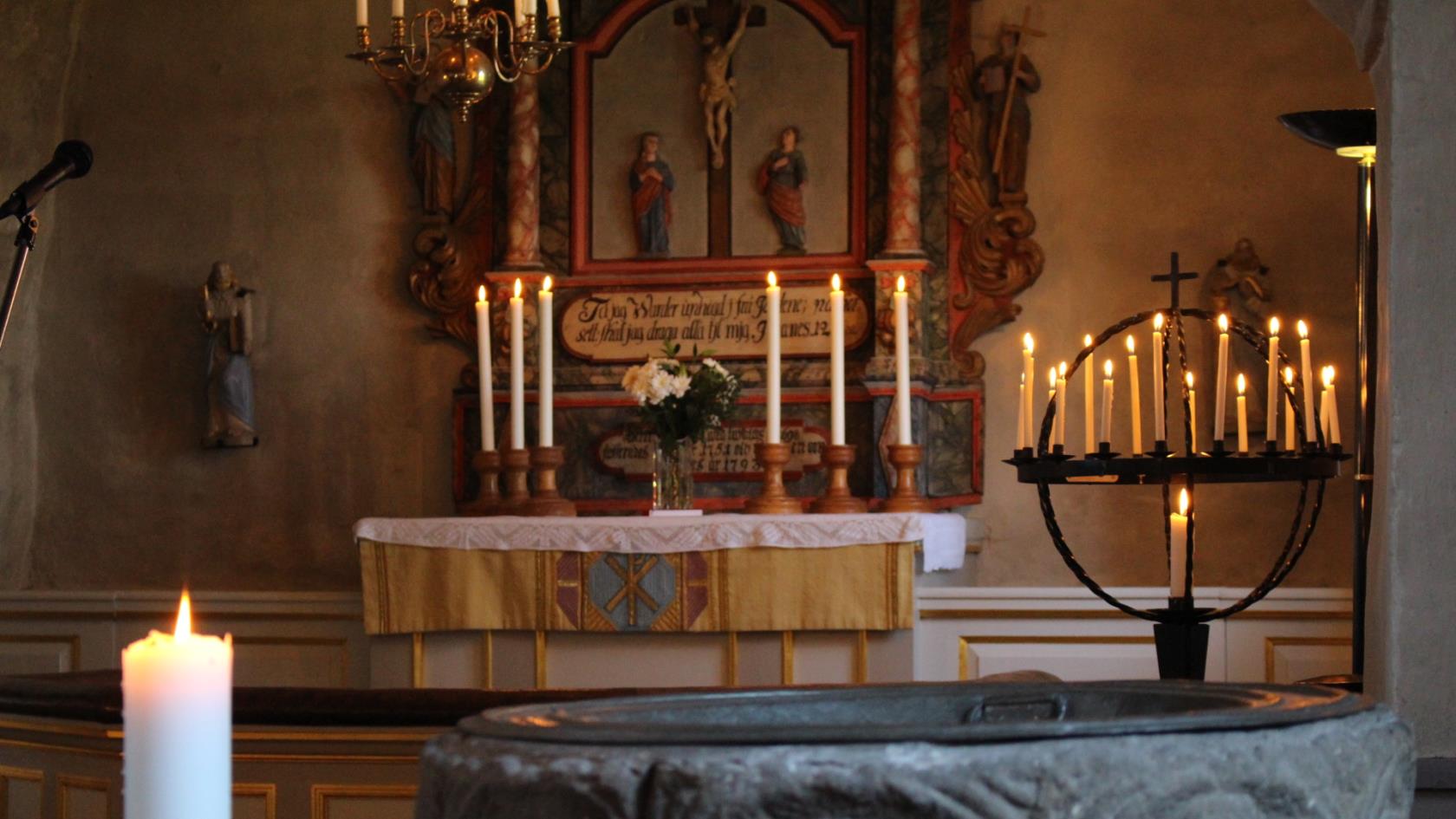 Tända ljus på altare och ljusbärare i Söne kyrka