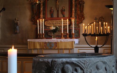 Tända ljus på altare och ljusbärare i Söne kyrka