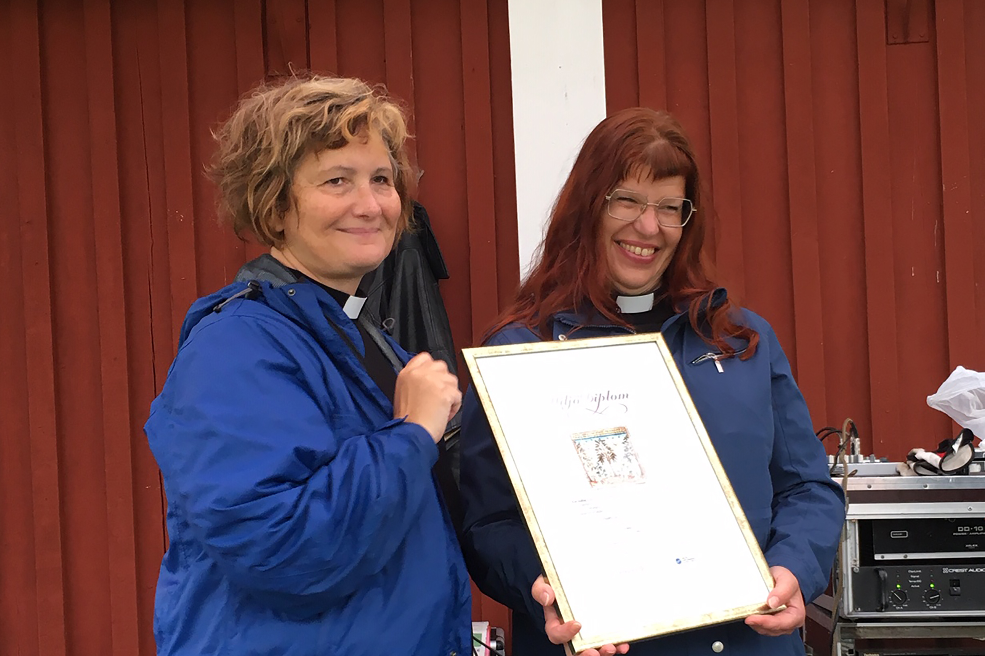 Biträdande kyrkoherde Anna Grenholm tar emot miljödiplomet av domprost Charlotte Rehnman.
