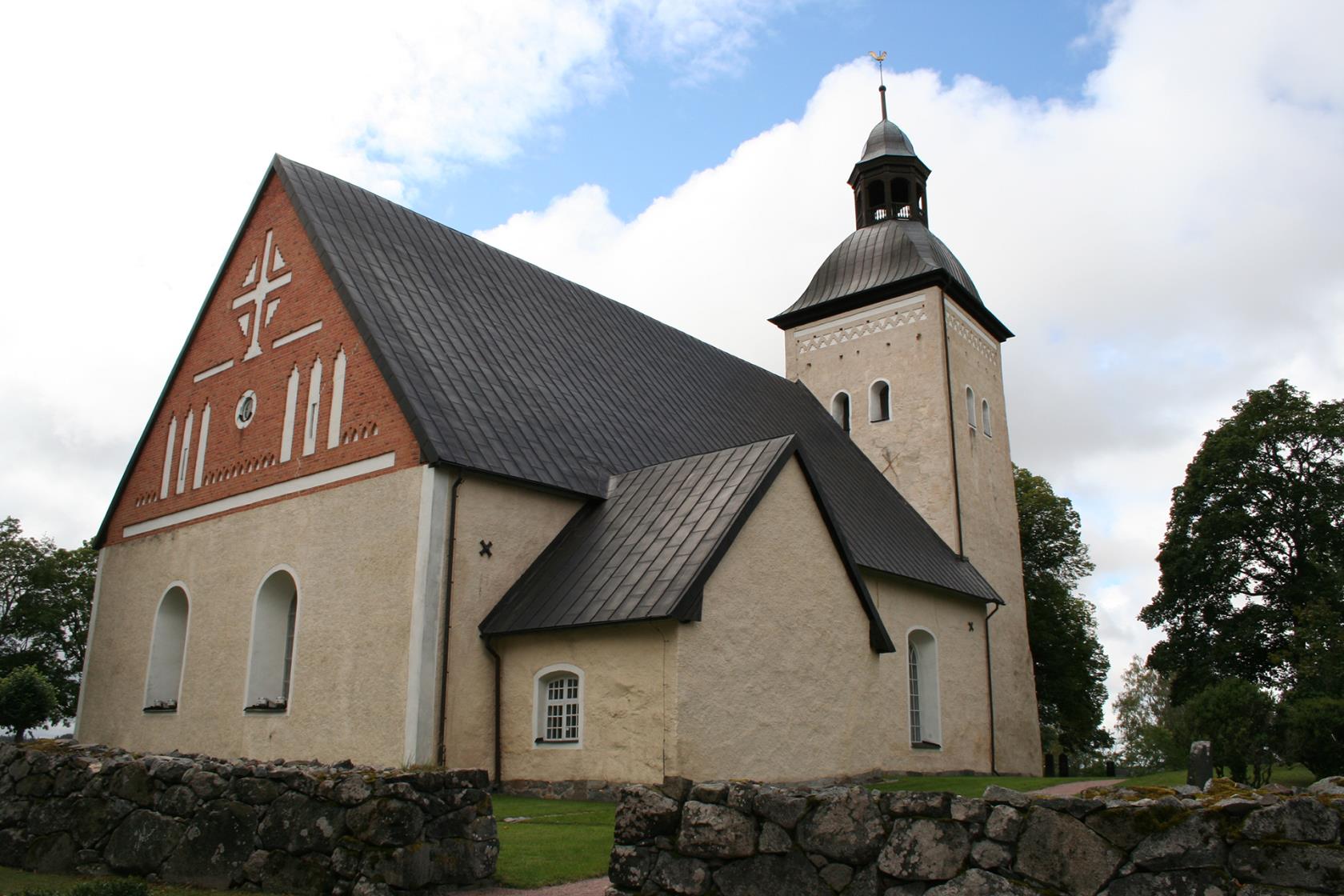 gul kyrka med stenmur