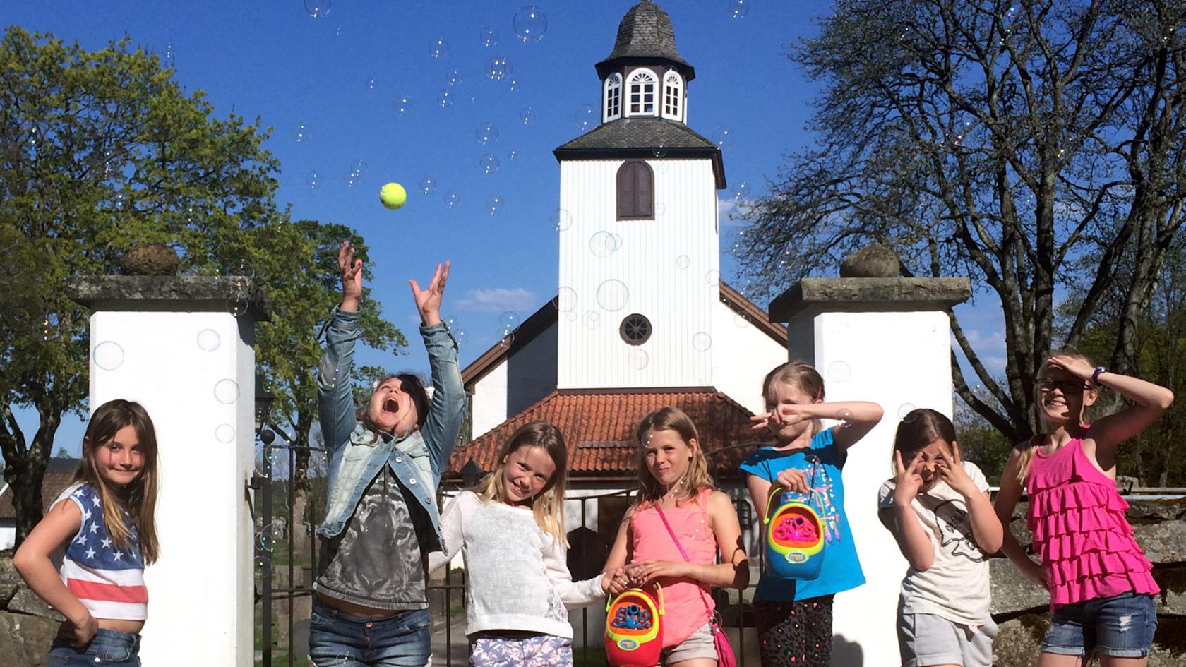 Barngruppen Kompis utanför Norums kyrka. Såpbubblor. Barn