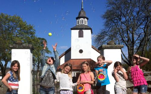 Barngruppen Kompis utanför Norums kyrka. Såpbubblor. Barn