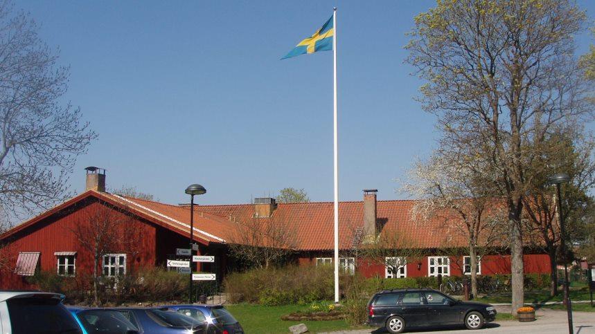 Mathiasgården en vacker vårdag, svenska flaggan svajar i vinden.