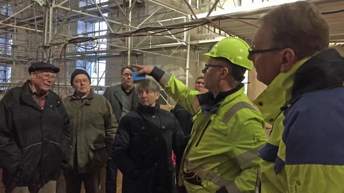 Anders Pers (t h) och Leif Sund (i hjälm) berättade om renoveringen av Gagnefs kyrka vid den öppna visningen den 21 mars.