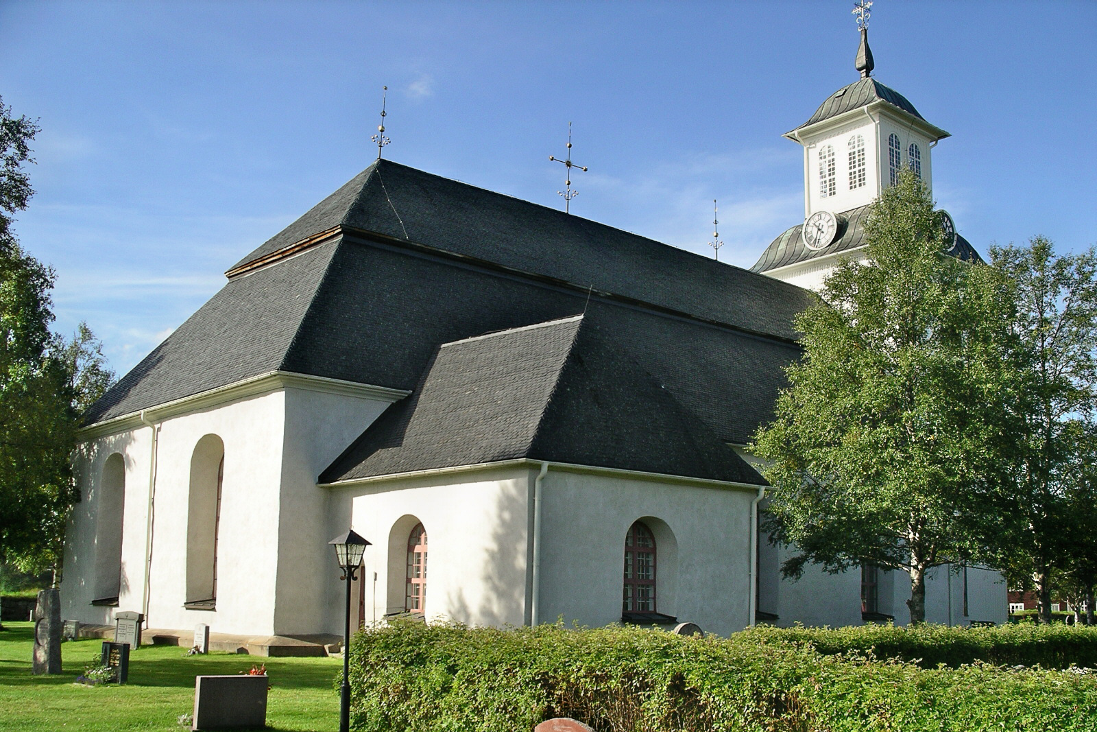 Runtomkring Lillhärdals kyrka är häckar och träd gröna.