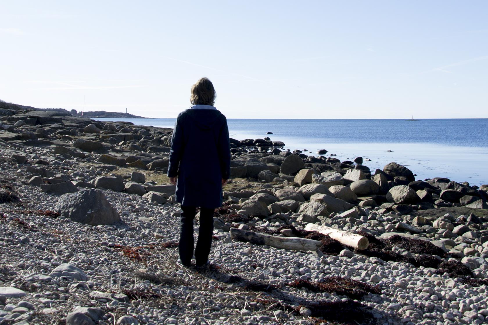 En kvinna står och tittar ut över havet.