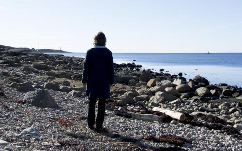 En kvinna står och tittar ut över havet.