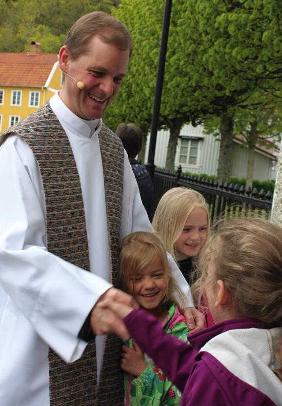 Mikael Isacson hälsar på barnen vid Kungälvs kyrka.