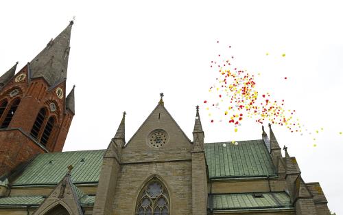 Bilden visar S:t Nicolai kyrka i centrala Örebro och ett ballongsläpp.