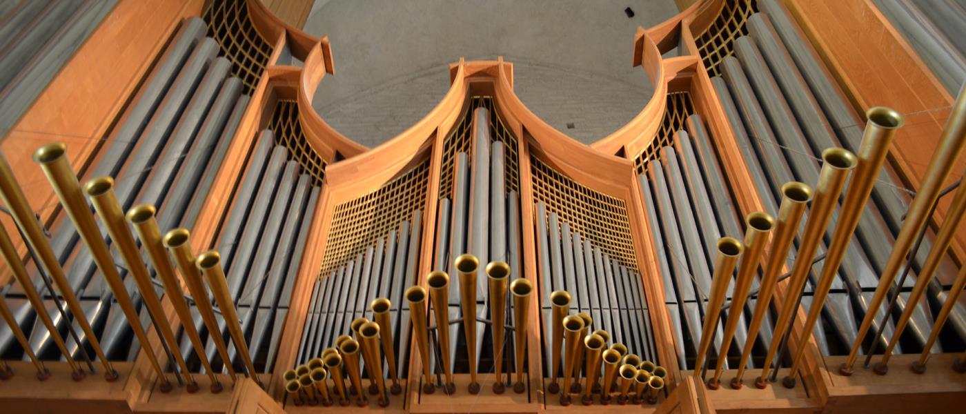 Närbild på en stor orgel med många pipor.