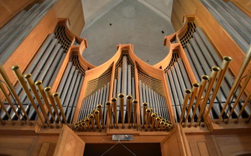 Närbild på en stor orgel med många pipor.