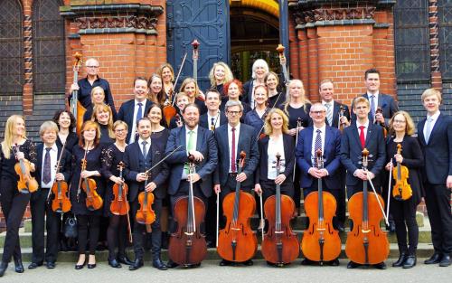 Gruppbild av Sinfoniettan utanför Oscar Fredriks kyrka. 