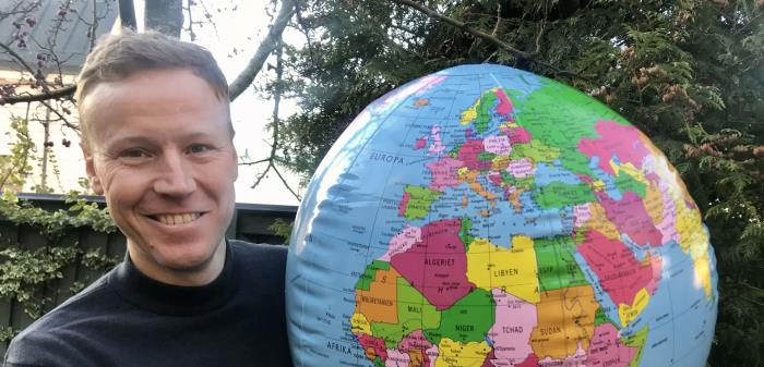Bilden visar kyrkogårdschef Per Gustafsson med en stor jordglob.