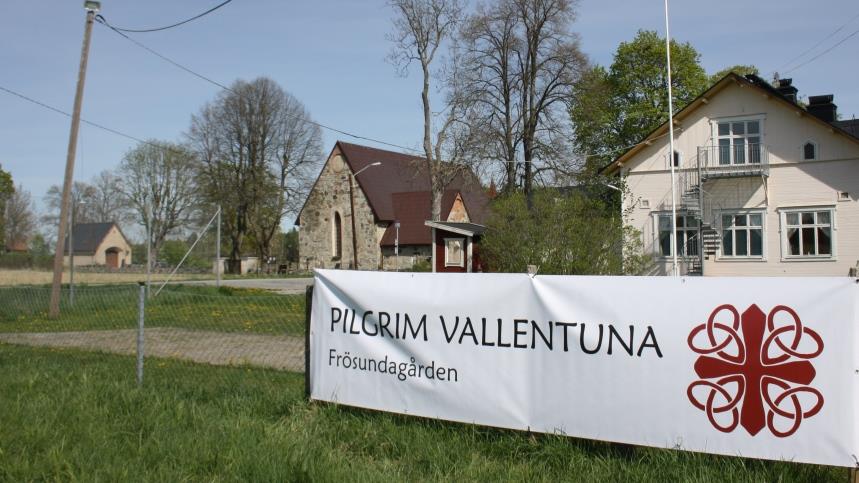 En banderoll på ett staket, med texten Pilgrim Vallentuna, Frösundagården