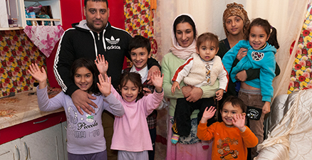 En grupp människor, två vuxna och sju barn, som är glada