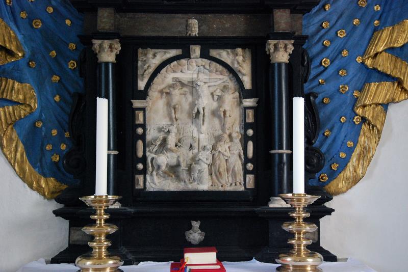 Altaruppsatsen i Sövestad kyrka är gjord i svart kalksten med reliefer i alabaster och carraramarmor.  Tavlan har motiv från Golgata.