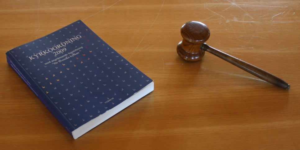 Kyrkoförordningen och en ordförandeklubba på ett bord