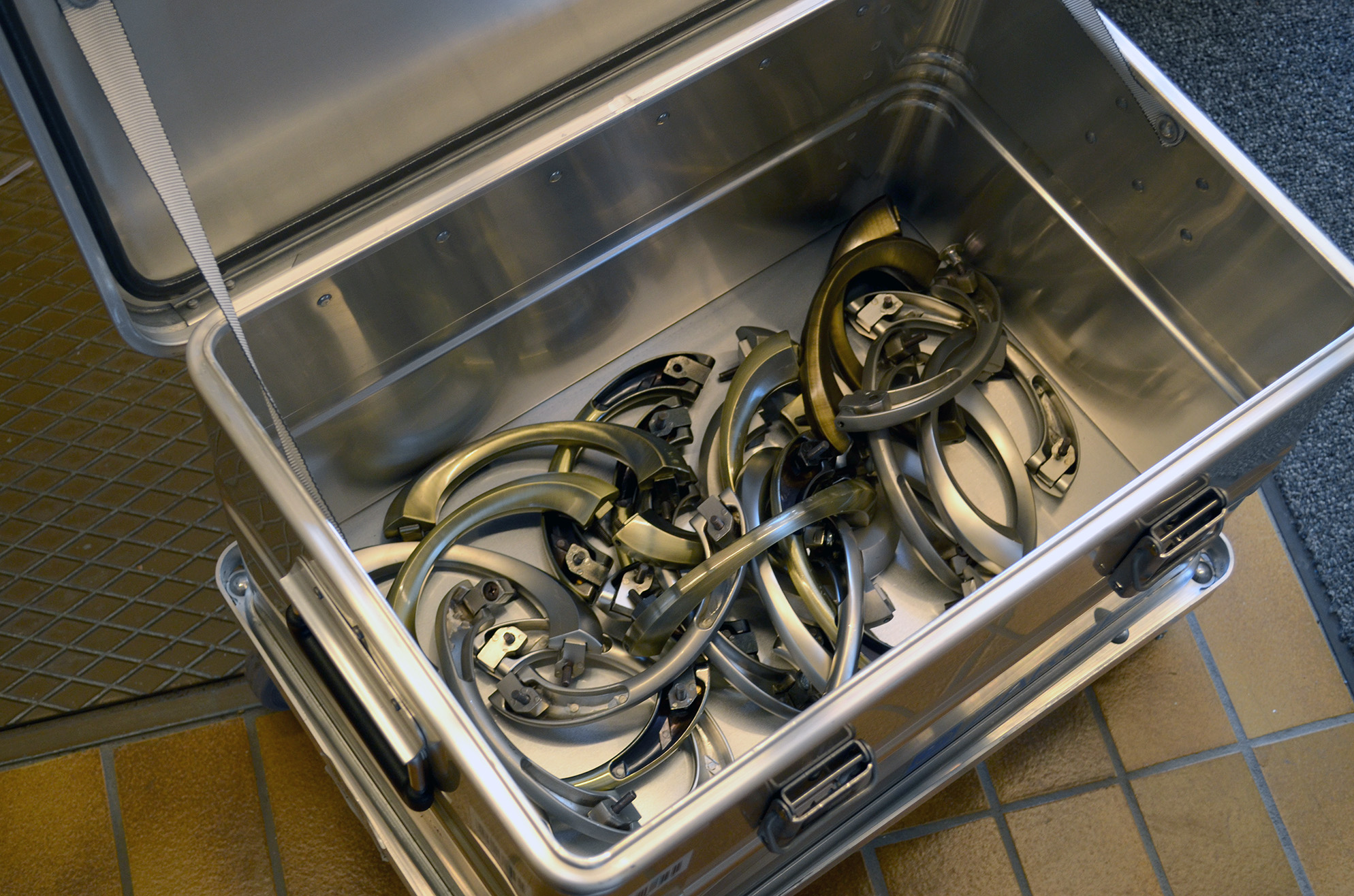 Före kremering avlägsnas kisthandtagen. De samlas i en särskild behållare för vidare transport till återvinningsföretaget. 