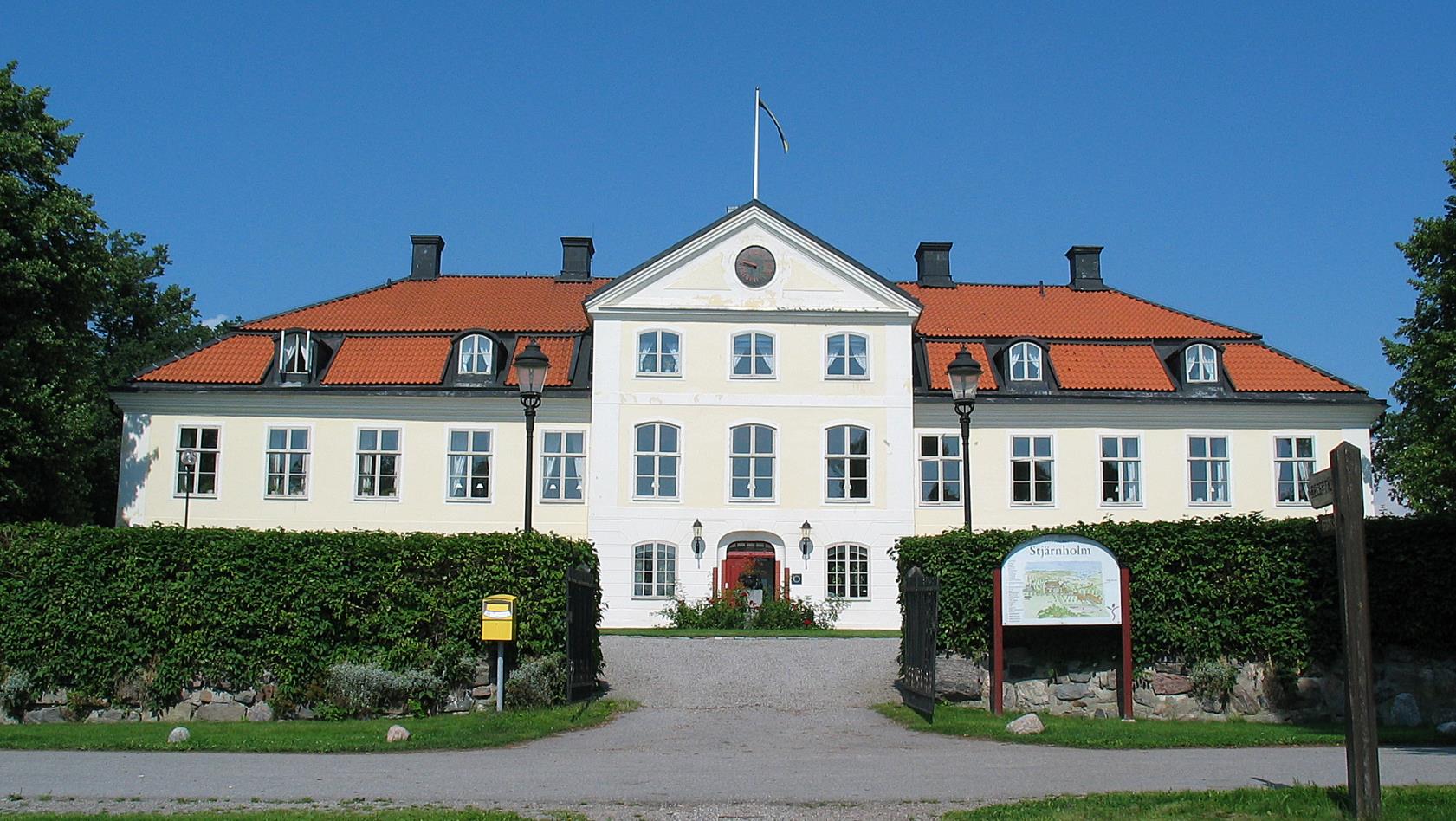 Stiftsgården Stjärnholm rakt framifrån mot en blå himmel.