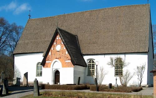 Vit medeltida kyrka i solljus