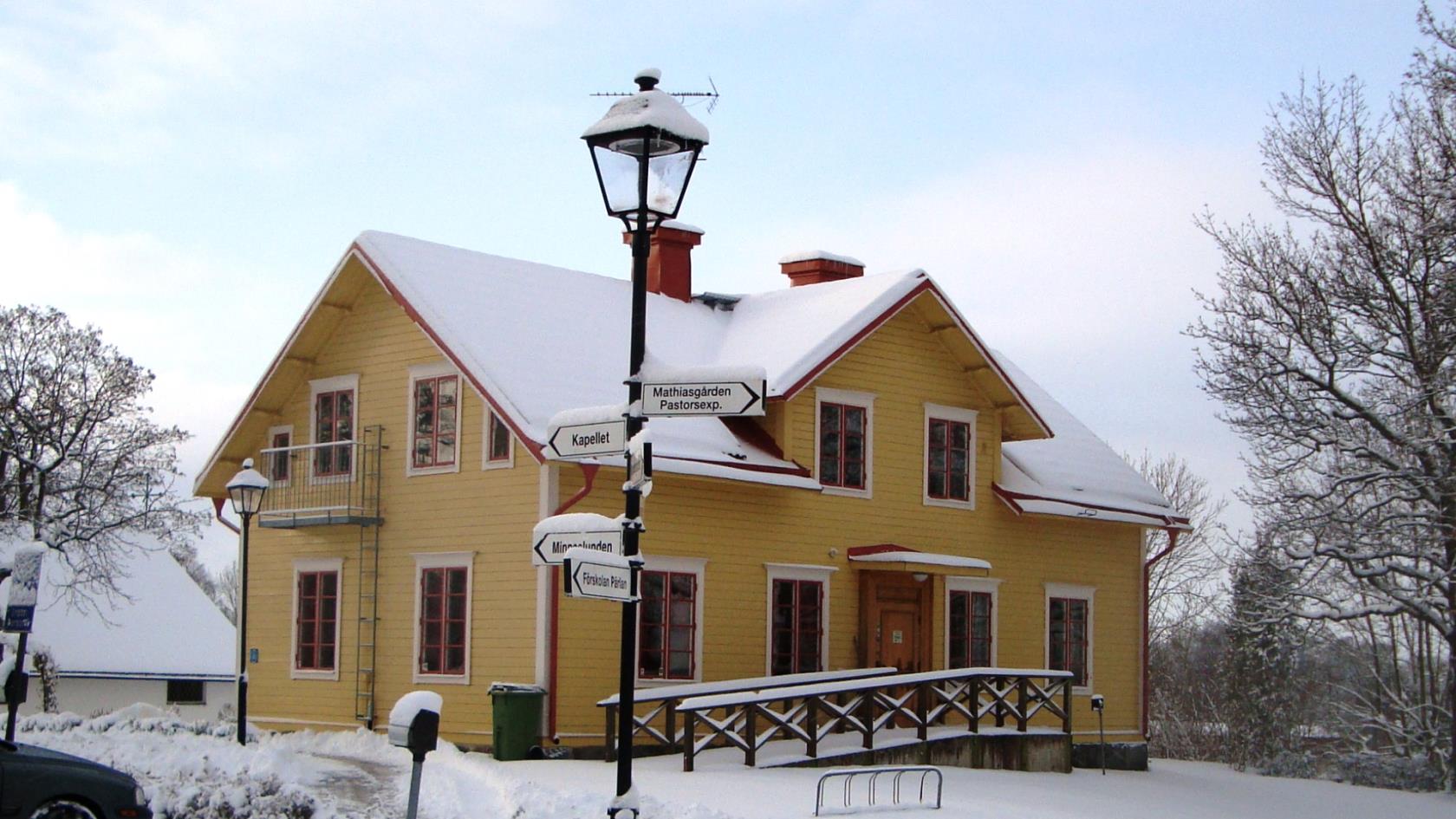 Ett gult hus, med snö på taket och runt om - Stefansgården vintertid